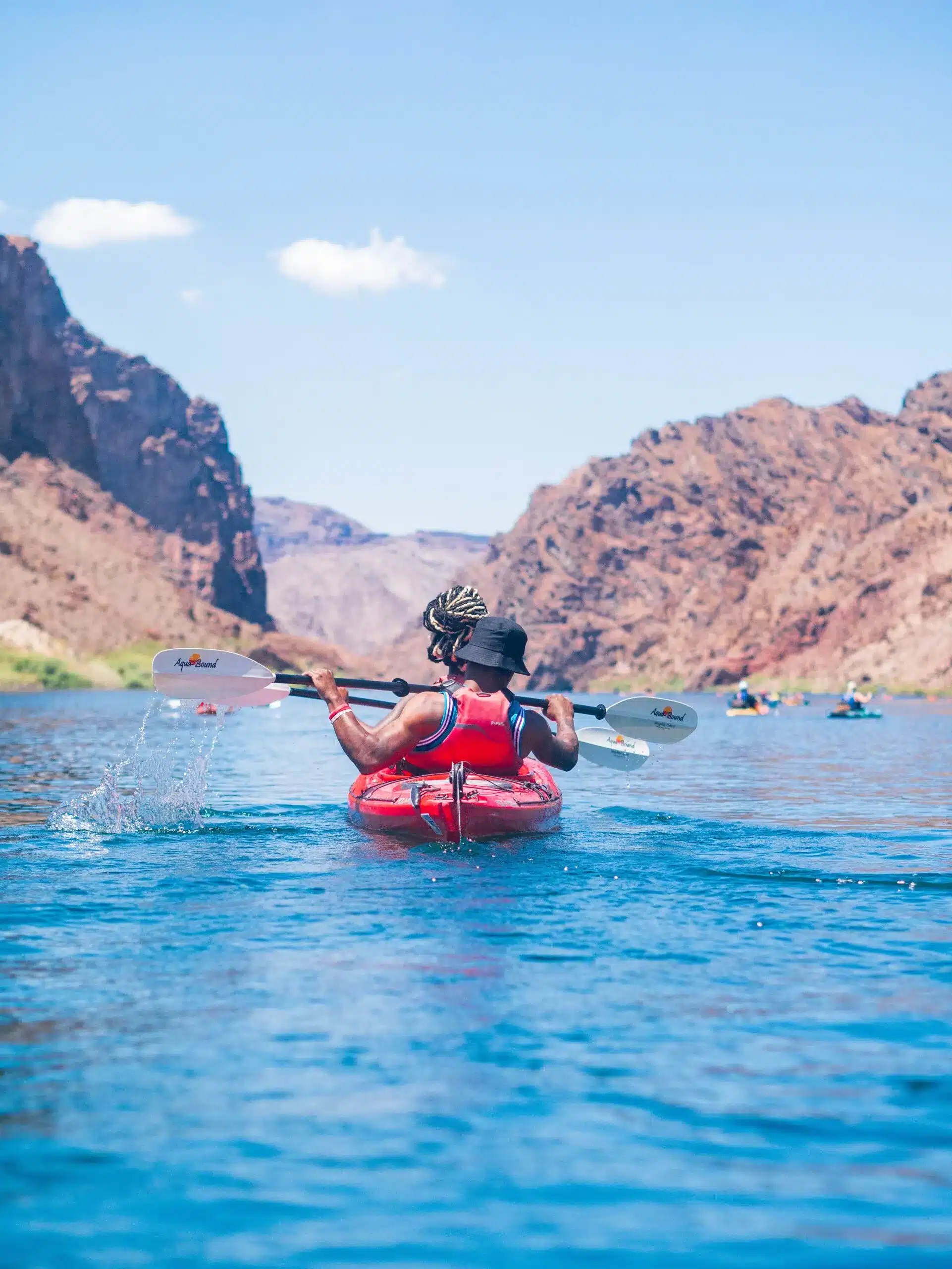 Kayakers paddling through desert canyon walls on the Colorado River