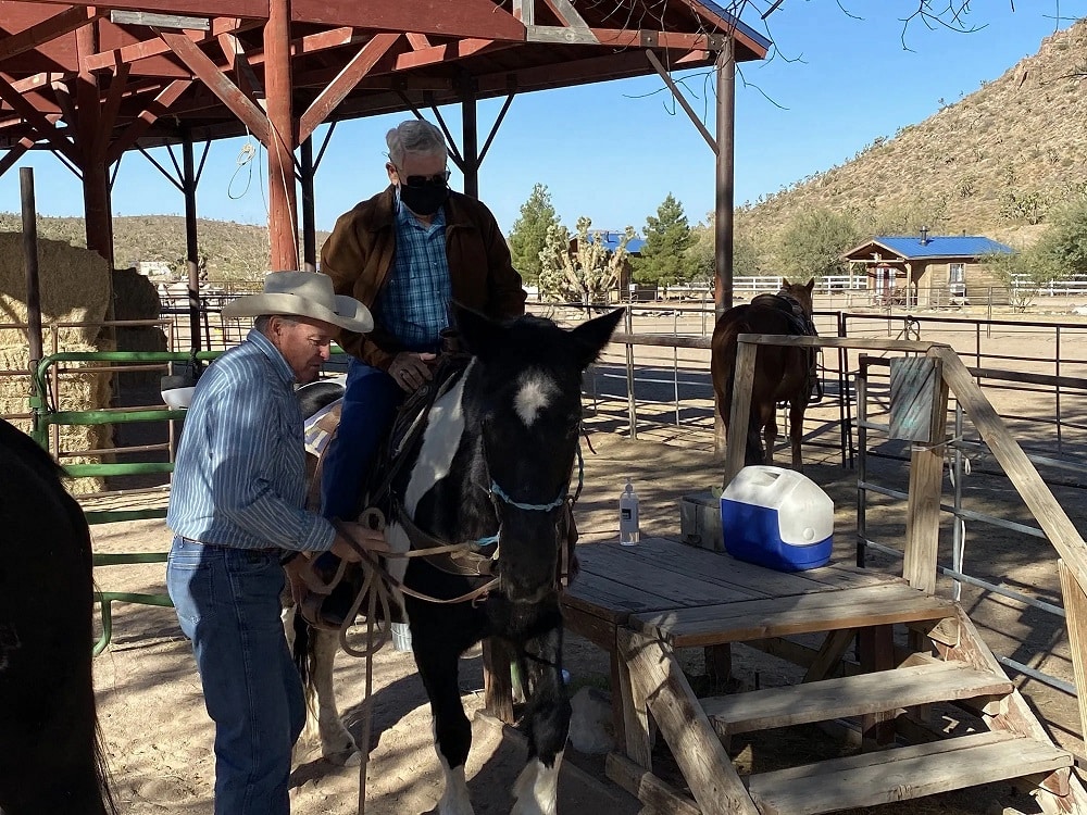 Expert cowboy guide leading the horseback tour through the forest